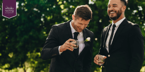Groom and best man drinking whisky from best man gift
